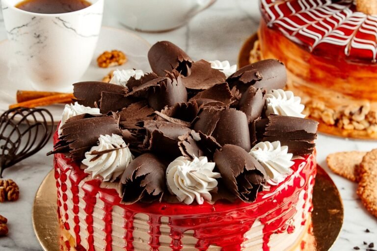 side-view-fruit-cake-topped-with-chocolate-curl-whipped-cream-table-served-with-tea-1.jpg